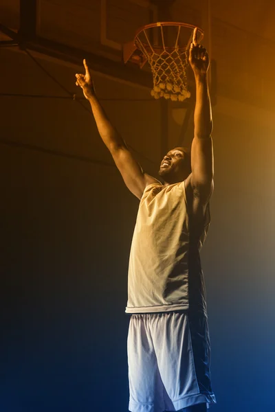 Basketball player throwing arms for victory