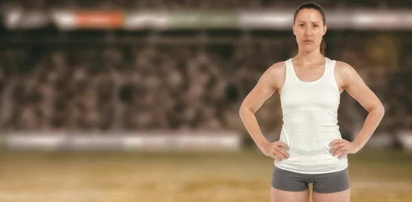 Female athlete standing with hands on hips
