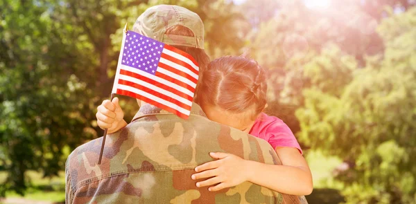 Army man hugging daughter