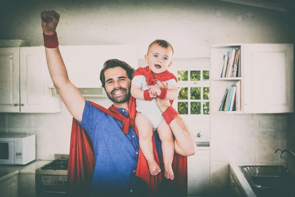 Father in superhero costume lifting son