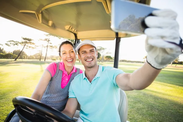 Golfer couple taking selfie