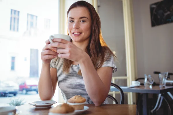 Woman sitting with coffee at cafeteria