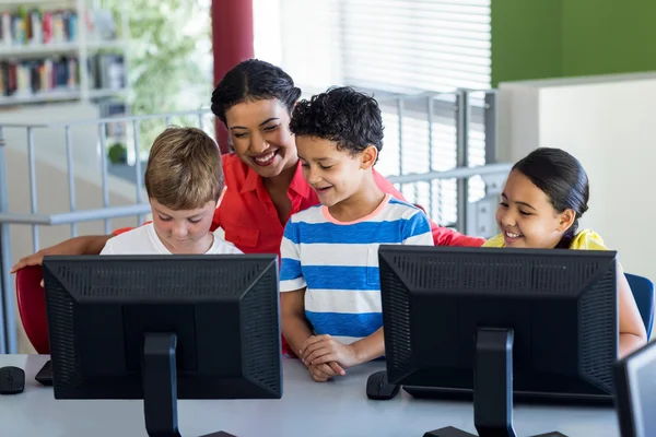 Teacher with children during computer class