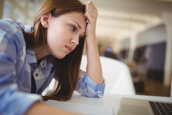 Stressed businesswoman with head in hand