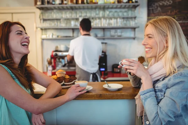 Customers talking at counter in coffee shop