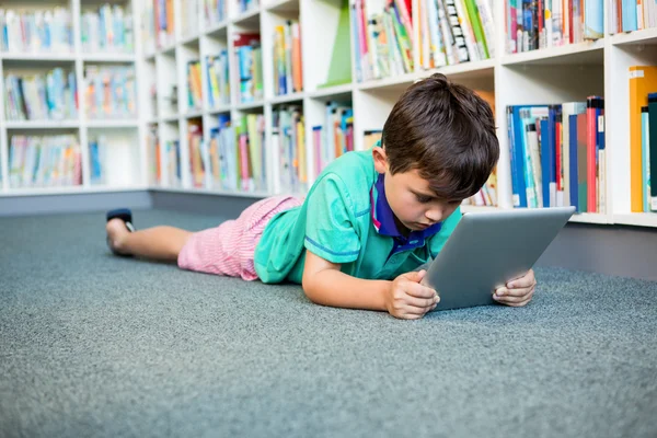 Boy using tablet in school library