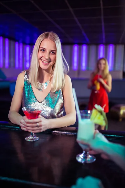 Woman enjoying cocktail at bar counter