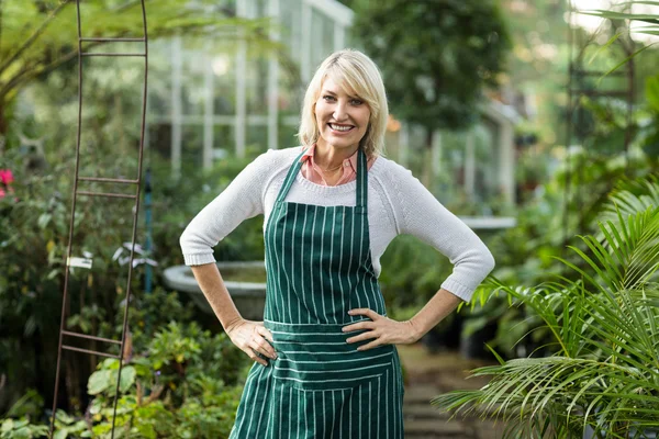 Woman standing with hand on hip at greenhouse