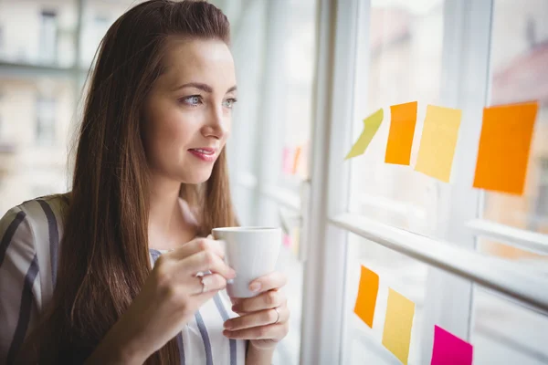 Businesswoman looking through window