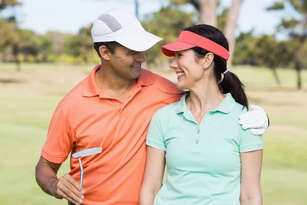 Golfer couple with arm around