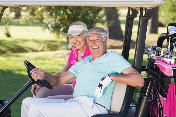 Cheerful golfer couple sitting in golf buggy