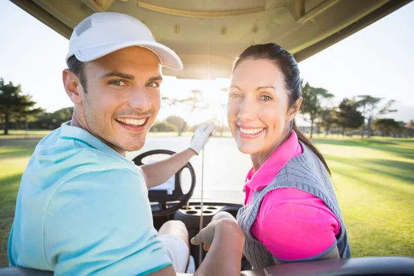 Golfer couple sitting in golf bugggy