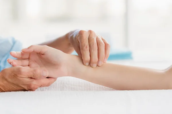Masseur giving hand massage to woman