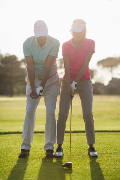 Mature male golfer teaching woman