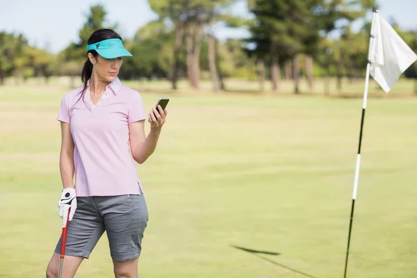 Golfer woman using phone