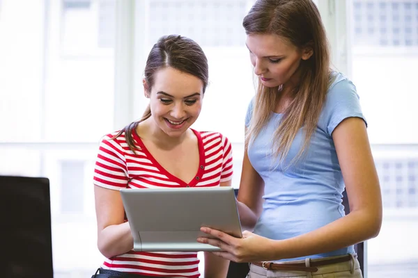 Executive showing colleague in tablet