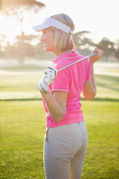 Woman golfer holding her club