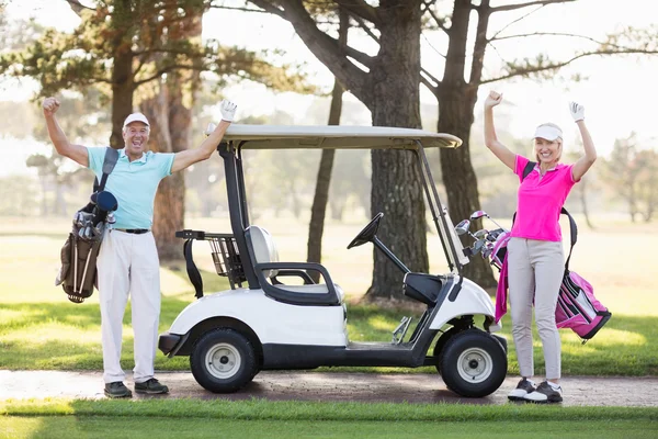 Mature golfer couple with arms raised