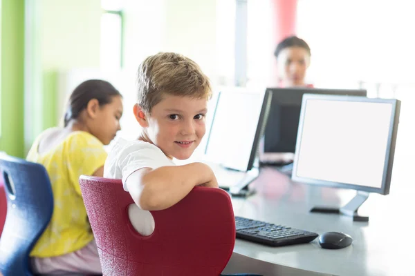 Boy with classmates and teacher in computer room