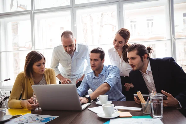 Creative business people looking at laptop