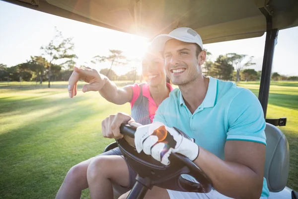 Smiling golfer woman pointing by man