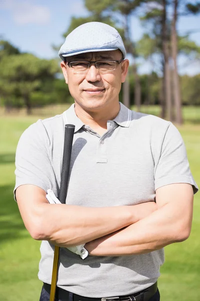 Happy golfer with arms crossed