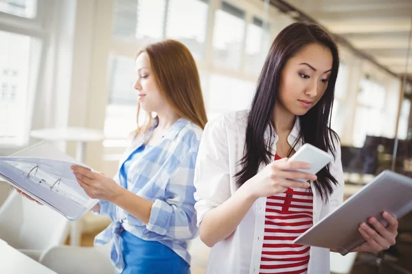 Female colleagues holding files and phone