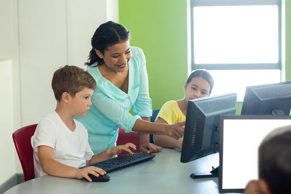 Teacher teaching computer to children