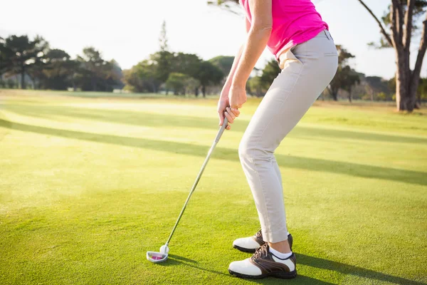 Woman golfer preparing her shot