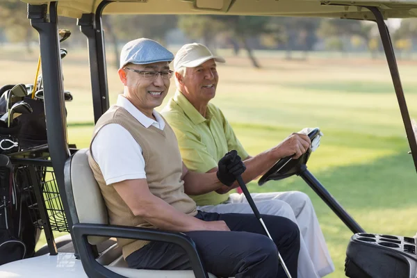 Golfer friends in golf buggy