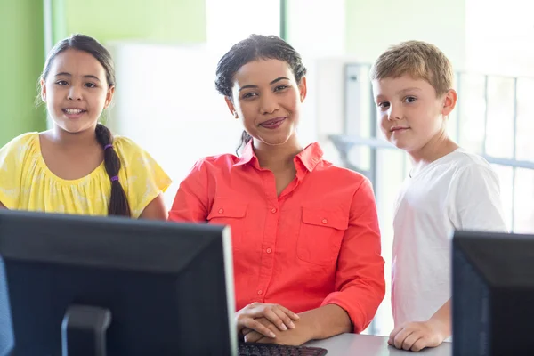 Female teacher with children in computer class