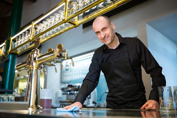 Bar tender cleaning bar counter