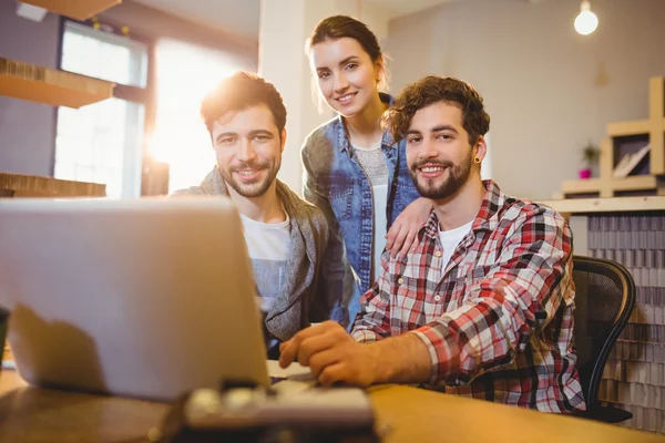 Graphic designer using laptop with his coworker