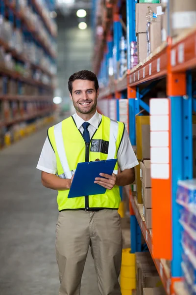 Worker with clipboard looking at camera