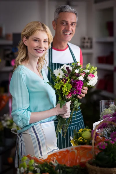 Smiling florists holding bunch of flowers