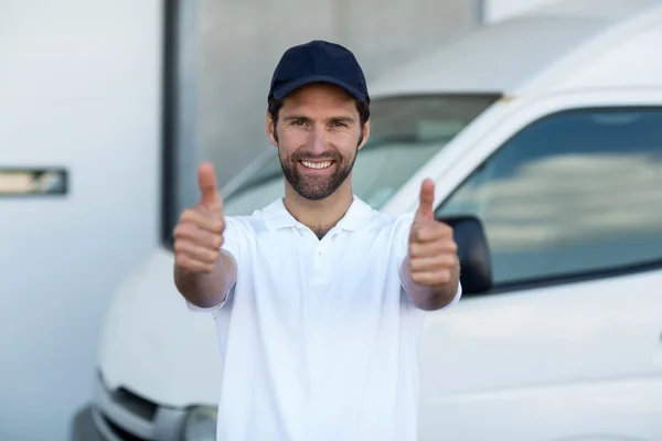 Delivery man is posing and smiling with thumbs up