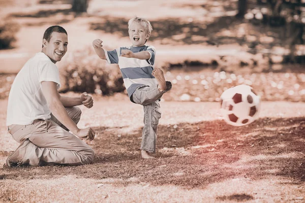 Father playing football with son