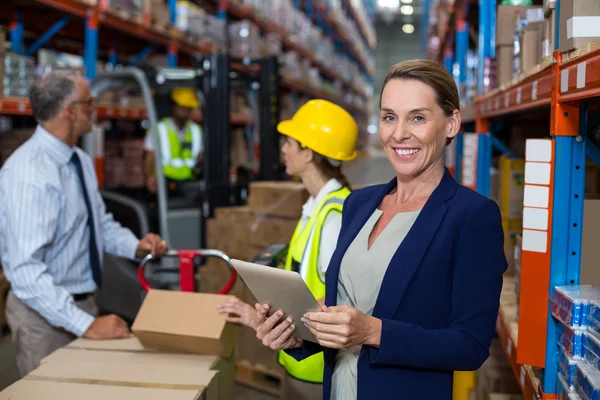 Business woman standing in front warehouse worker