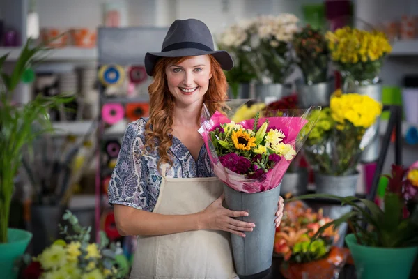 Happy female florist holding flower vase