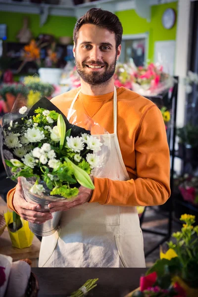 Male florist holding flower bouquet at flower shop