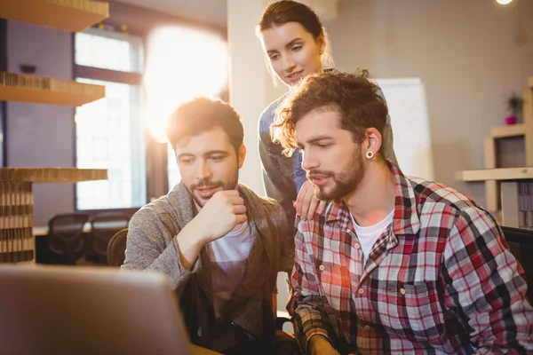 Graphic designer using laptop with his coworker