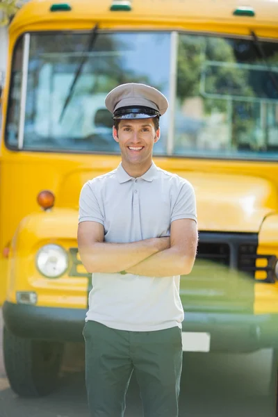 Smiling bus driver standing with arms crossed