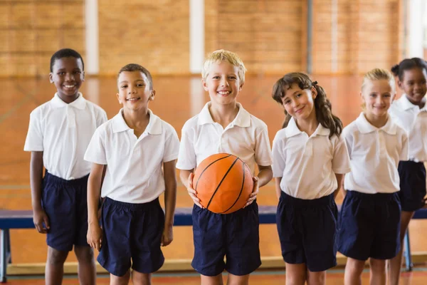 Smiling students standing with basketball