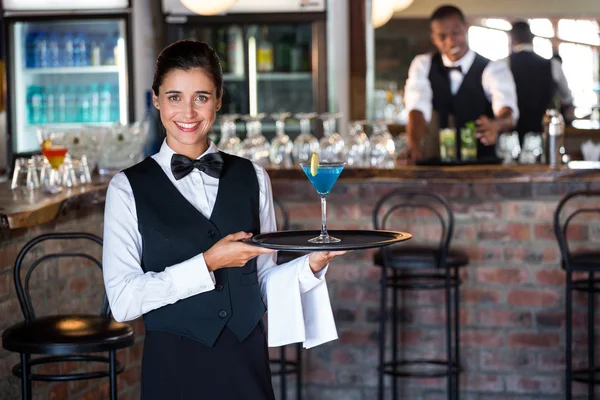 Bartender holding serving tray with glass