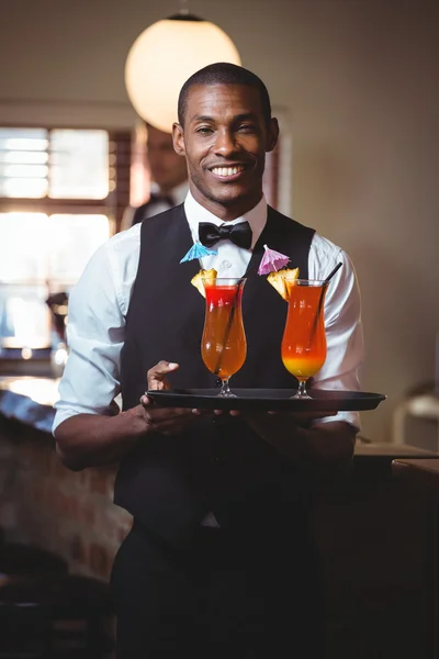 Bartender holding serving tray with two glass of cocktail