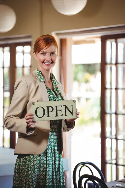 Woman holding a sign with open