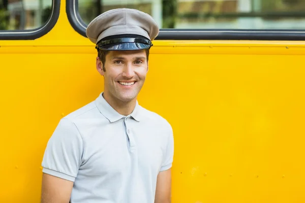 Bus driver smiling in front of bus