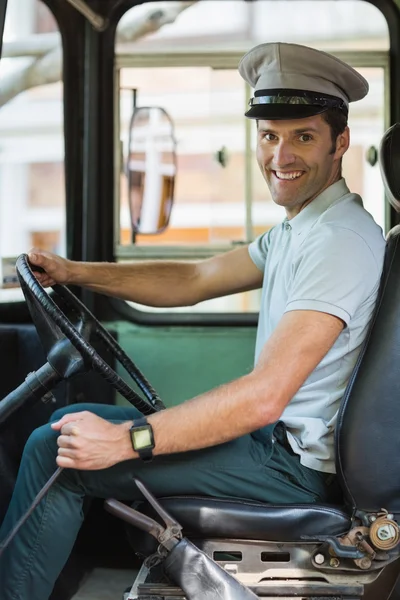 Smiling bus driver driving a bus