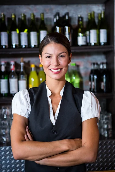 Smiling waitress with arms crossed