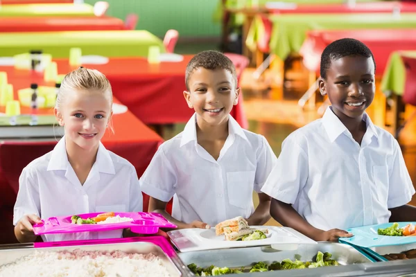 Portrait of school kids having lunch during break time